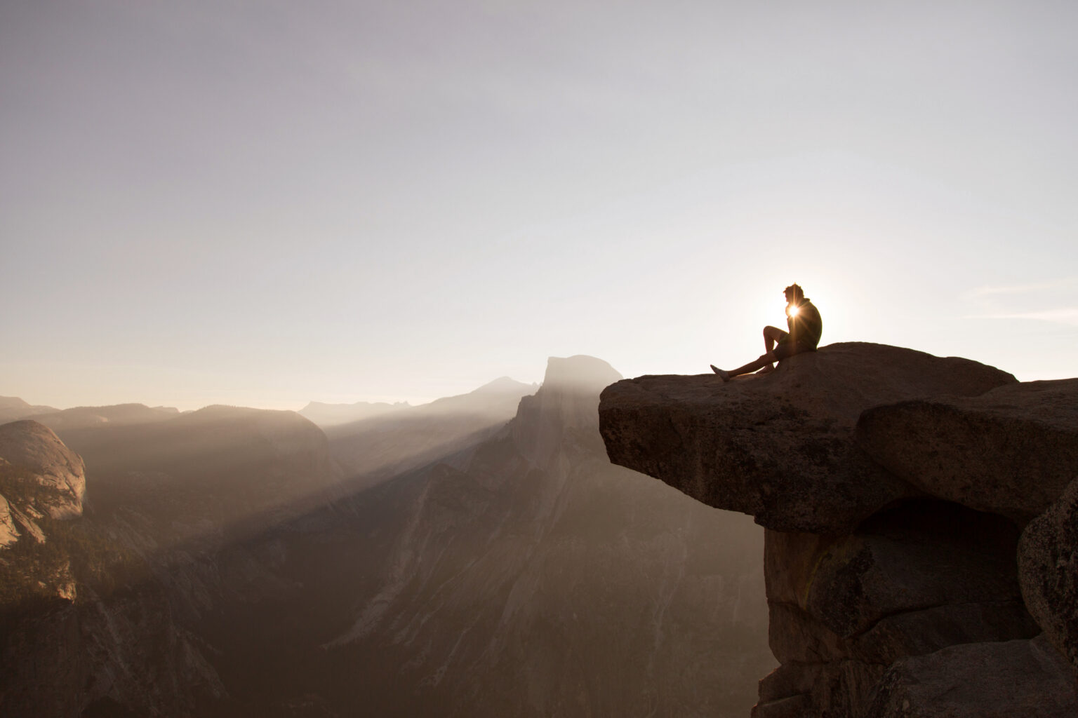 Photo of a person watching a sunset from a mountain