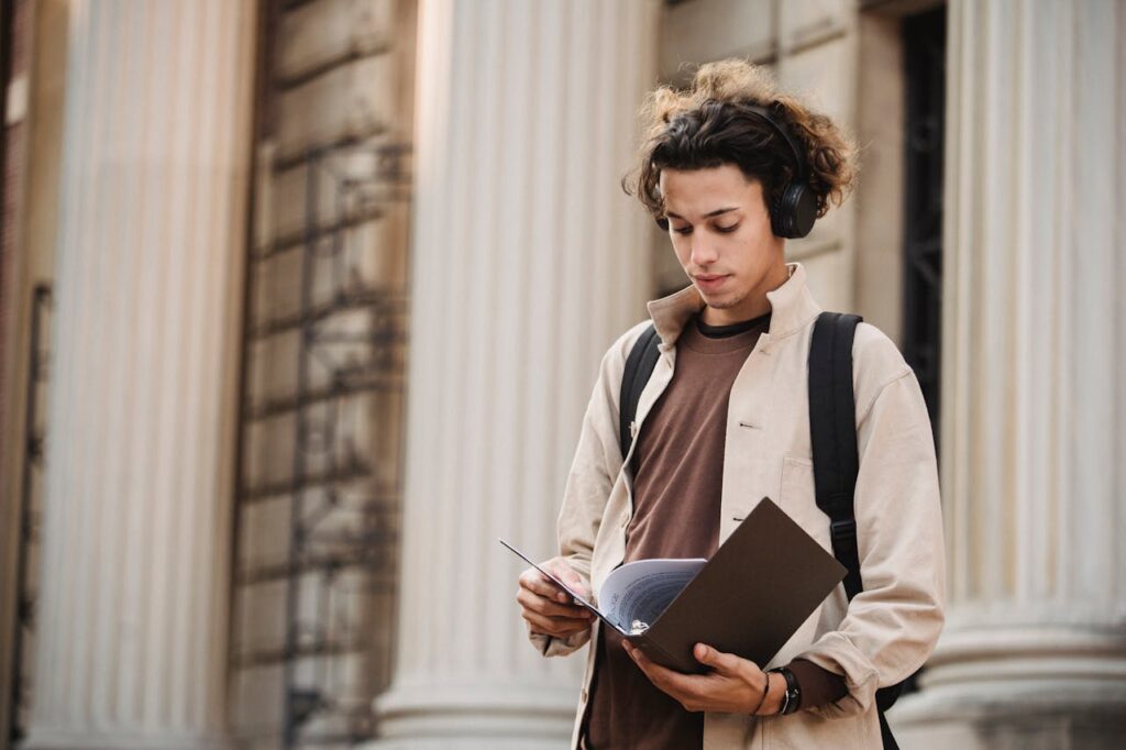 serious-student-reading-documents-in-folder