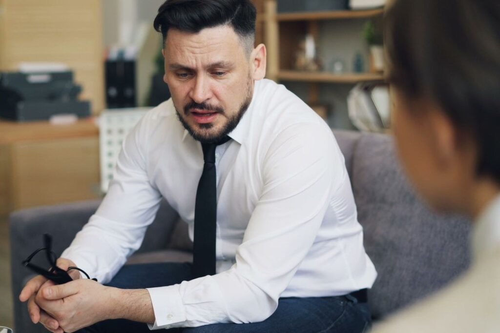 How Mental Health Therapy Can Support Chronic Pain Management 2 a-man-sitting-on-a-couch-talking-to-a-woman
